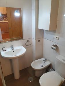 a white bathroom with a toilet and a sink at 2H, Aire Acondic, 50m2, 1 dormitorio, 4 huéspedes, WIFI GRATIS in La Línea de la Concepción
