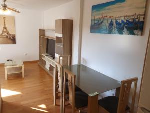 a dining room with a table and a tv at 2H, Aire Acondic, 50m2, 1 dormitorio, 4 huéspedes, WIFI GRATIS in La Línea de la Concepción +10 photos