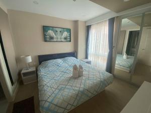 een slaapkamer met een bed met schoenen erop bij ΛPΛRTMENTS in Seven Seas condo in Jomtien Beach