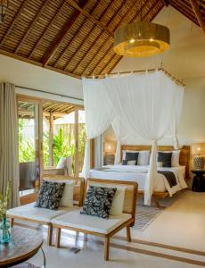 a bedroom with a bed and two couches at Gypsea Bali in Uluwatu