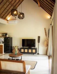 uma sala de estar com uma televisão e uma mesa em Gypsea Bali em Uluwatu