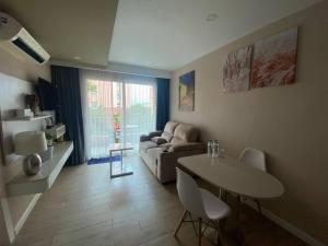 een woonkamer met een bank en een tafel bij ΛPΛRTMENTS in Seven Seas condo in Jomtien Beach +51 foto's