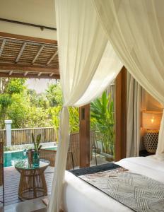 a bedroom with a bed and a patio with a table at Gypsea Bali in Uluwatu