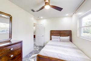 een slaapkamer met een bed en een plafondventilator bij By the Beach - Main in Jacksonville