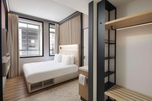 um quarto com uma cama branca e uma janela em Motto By Hilton Rotterdam Blaak em Roterdã
