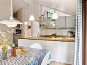 een keuken met een tafel met een blauw en wit tafelkleed bij Holiday Home Wilgrib - 400m from the sea in Sealand by Interhome in Højby