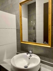 a bathroom with a white sink and a mirror at The Podium-12 Pax in Kuching
