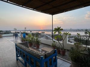 a blue bench on a balcony with a view of the water at Comfy Apartments in Harmony House - Nile View in Luxor