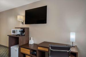 Habitación de hotel con escritorio y TV en la pared en SureStay Hotel by Best Western Williams - Grand Canyon en Williams