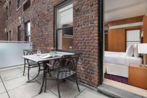 a balcony with a table and chairs on a brick wall at Hotel 57 in New York