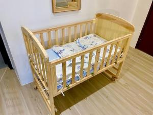 a wooden baby crib in a room with at The Podium-12 Pax in Kuching