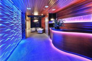 a lobby with a bar with blue and purple lights at Condor Hotel by LuxUrban, Trademark Collection by Wyndham in Brooklyn