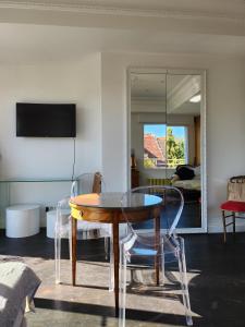 - une salle à manger avec une table, des chaises et un miroir dans l'établissement L'Orangerie, à Strasbourg