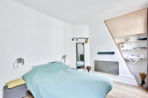 a bedroom with a bed and a mirror at Bright studio just a stone's throw from the Bataclan in Paris