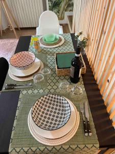 una mesa con platos y una botella de vino. en the green nest, en Olginate