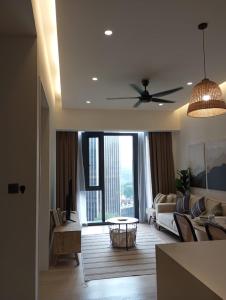 KLCC Beyond Hospitality Suites STAR في كوالالمبور: غرفة معيشة مع أريكة ومروحة سقف