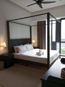 um quarto com uma cama grande e uma ventoinha de tecto em KLCC Beyond Hospitality Suites STAR em Kuala Lumpur