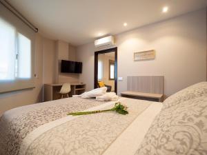 una habitación de hotel con una cama con una flor. en ESTUDIOS DOÑA MANUELA, en Daimiel