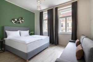 1 dormitorio con 1 cama y 1 sofá en Kinsky Garden Apartments and Suites, en Praga