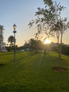 un parc avec un pôle lumineux et un arbre dans l'établissement Appartement à résidence Ap8 , marina , saidia, à Berkane