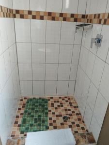 La salle de bains est pourvue d'une douche et de carrelage. dans l'établissement Looks cottages self catering apartments, à Kasane