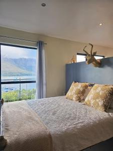 a bedroom with a large bed with a large window at Best Place Ever in Hout Bay