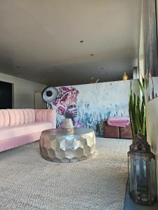 a living room with a pink couch and a table at Best Place Ever in Hout Bay