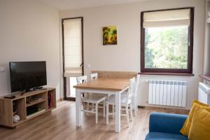 a living room with a table and a tv at All Seasons Apartments Borovets Gardens in Borovets