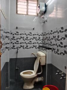 a bathroom with a toilet and a shower at Hotel Everest Residency in Tiruvannāmalai