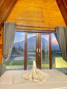 a bedroom with a bed with a large window at The Batur Elevation in Kubupenlokan