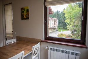 a dining room with a table and a large window at All Seasons Apartments Borovets Gardens in Borovets