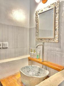 a bathroom with a large stone sink and a mirror at The Batur Elevation in Kubupenlokan