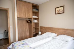 a bedroom with a white bed and a book shelf at All Seasons Apartments Borovets Gardens in Borovets
