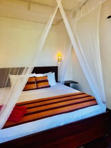 a bedroom with a bed with a mosquito net at Ella Festoon in Ella