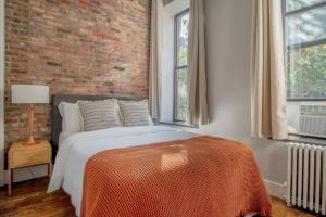 a bedroom with a bed and a brick wall at Nolita 1br w wd nr shopping groceries NYC-1220 in New York
