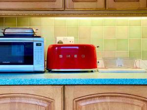 a red toaster sitting on a counter next to a microwave at Vintage Apartment in King's Cross in London