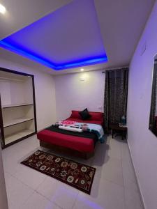 a bedroom with a red bed and a blue ceiling at Sumana Stays in Ooty