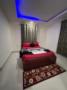 a bedroom with a bed with red pillows and a rug at Sumana Stays in Ooty