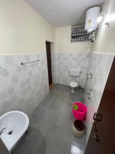 a bathroom with a white sink and a toilet at Sumana Stays in Ooty