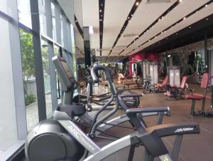 un gimnasio con filas de máquinas de cardio en un edificio en KLCC Ritz Residence STAR en Kuala Lumpur