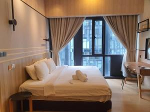 a bedroom with a bed with a desk and a window at KLCC Ritz Residence STAR in Kuala Lumpur