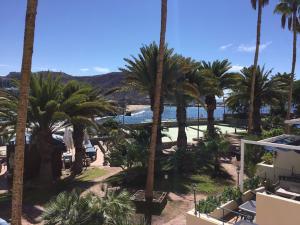 een uitzicht op het strand vanuit een resort met palmbomen bij Suite Monte Golf à Playa del Cura, Grande Canarie, le Soleil toute l’année, ici c’est possible ! in Playa del Cura