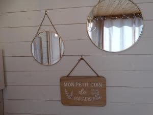 a bathroom with two mirrors and a sign on the wall at les lodges finlandais de la tortue permacole fine dentelle in Champclause