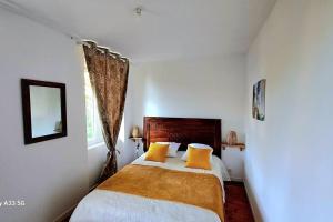 a bedroom with a large bed with yellow pillows at Domaine de Cachaou Villa Leyr'ial sauna & spa in Salles