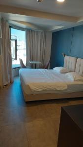 a bedroom with a large bed and a table at Moon TLV - 4th floor in Tel Aviv