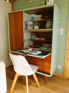 escritorio con silla blanca en una habitación en les Lodges de la tortue permacole Douce verveine, en Champclause