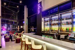 a bar at a hotel with chairs and a counter at Aloft Asuncion in Asuncion