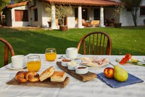 a table with a breakfast of bread and orange juice at Posada La Celia in Eugenio Bustos