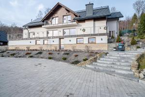 a large house with stairs in front of it at Willa Żar in Bialskie