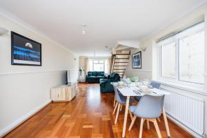 een woonkamer met een tafel en stoelen bij 2 Bedroom House by AV Stays Short Lets Croydon With Free Wi-Fi in South Norwood